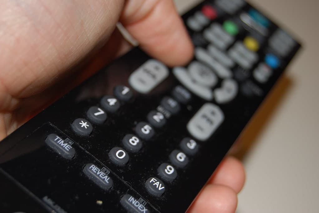 Hand hält eine TV-Fernbedienung
