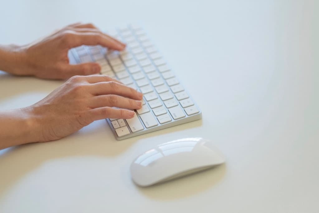Mains tapant sur un clavier d'ordinateur