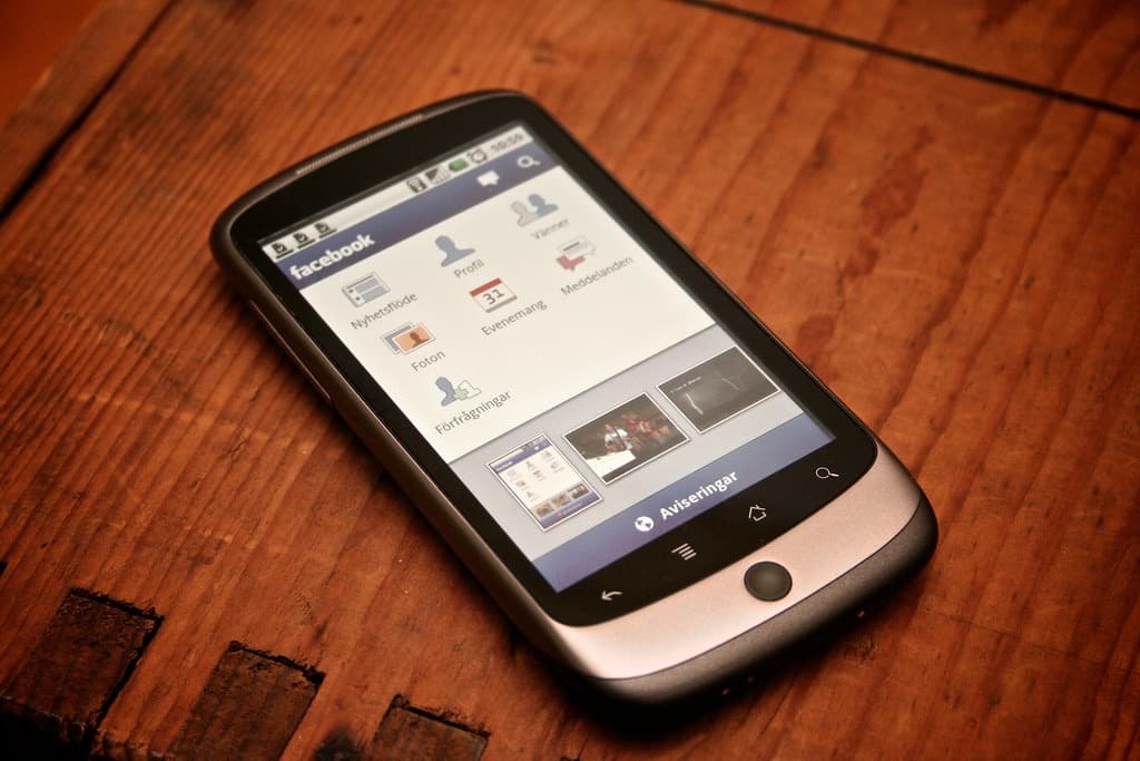 Smartphone met apps op een houten tafel